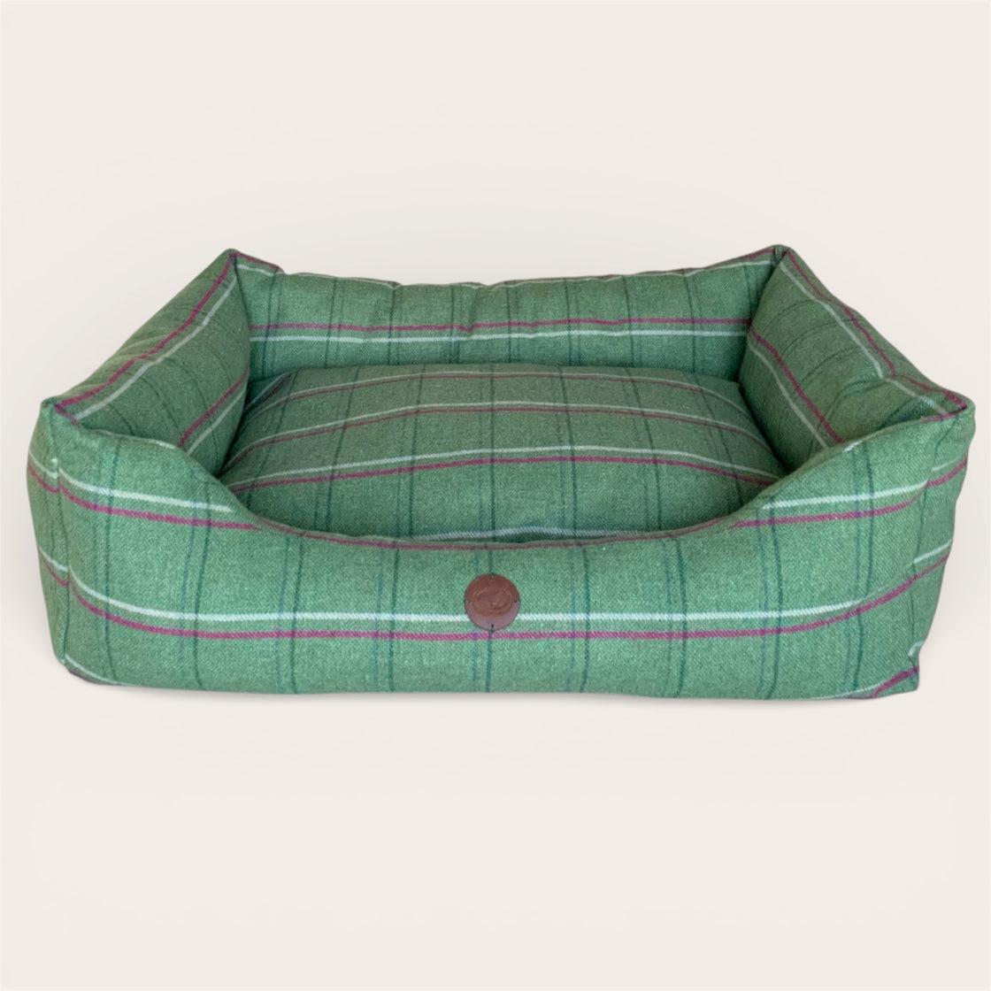Green tweed wool filled  pet bed with a brown button on a white background