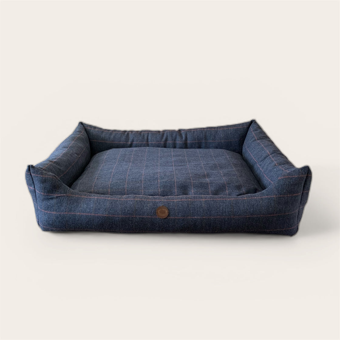 Wool filled Blue tweed pet bed with a button on a white background