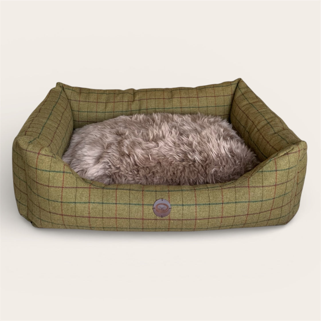 Wool filled Dog bed with green checkered fabric and genuine sheepskin on a white background